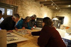 People looking at artifacts on a table in the Long Barrack