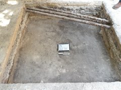 Three thin pipes across an excavation unit