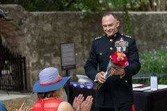 Marine General handing a bouquet of flowers to his wife during his retirement ceremony