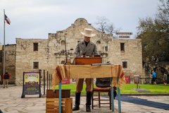 Reenactment of Travis writing letter in front of the Alamo Church