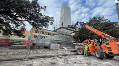 Orange construction truck next to scaffolding around Alamo Cenotaph