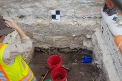 Two red buckets inside an excavation unit