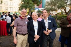 Three men smiling at an event in Alamo Gardens