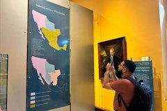 Man taking a picture of a large wall map