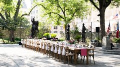 Farmhouse table set with wildflower arrangements in courtyard