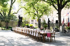 Farmhouse table set with wildflower arrangements in courtyard