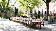 Farmhouse table set with wildflower arrangements in courtyard
