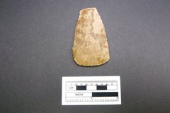 Stone tool artifact next to a ruler to show size