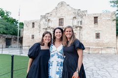 Three women smiling in front of Alamo Church