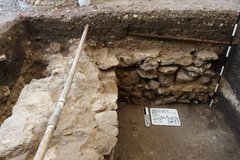 Layers of stone bordering interior of excavation unit