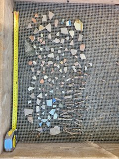 Artifact fragments arranged in rows on a mesh cover