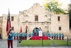 Texas Cavaliers lined up in full uniform in front of Alamo Church
