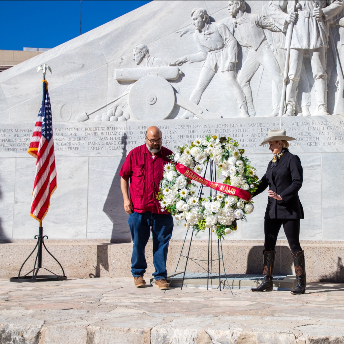 Commissioner Buckingham and Ernesto Rodriguez placing a white wreath at the Alamo Cenotaph