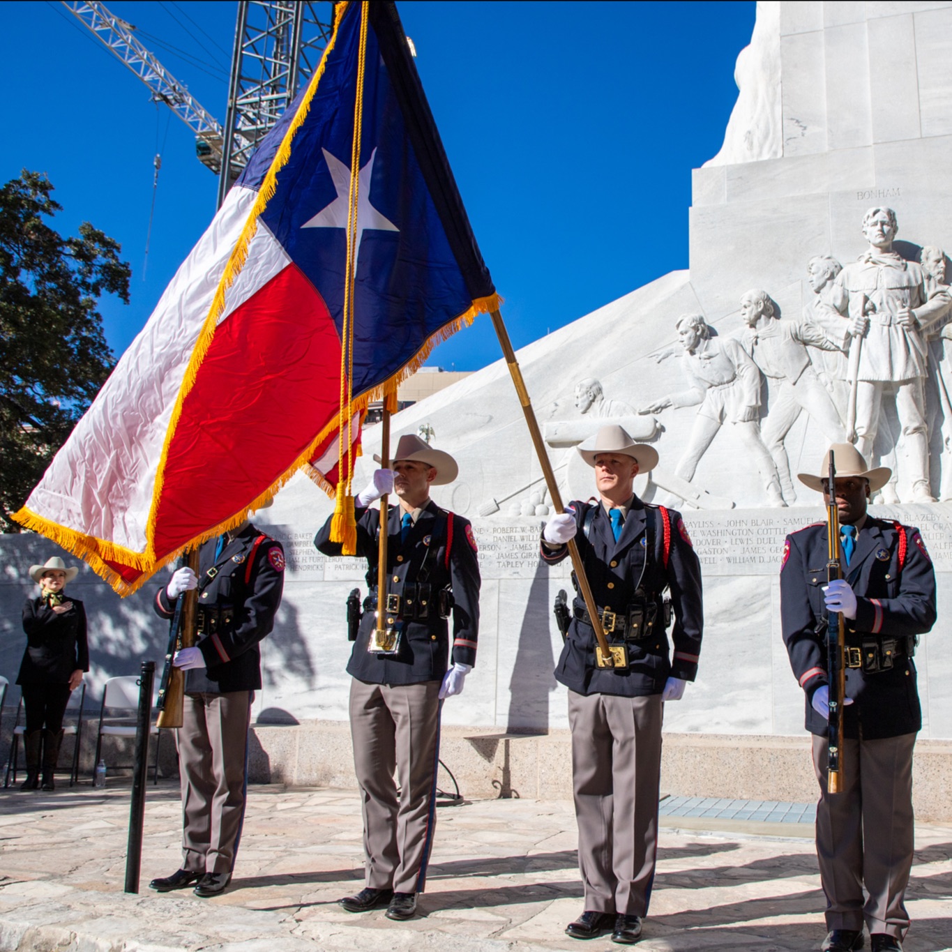 Color guard officers holding a Texas flag in front of Alamo Cenotaph