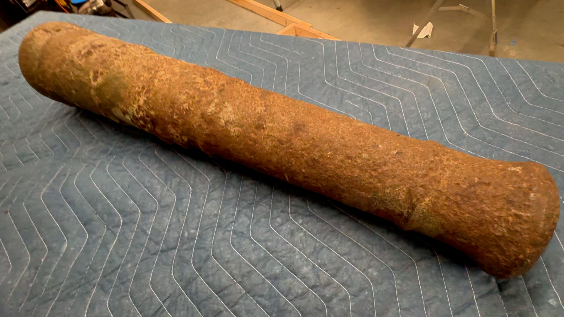Cannon covered in rust on a grey blanket