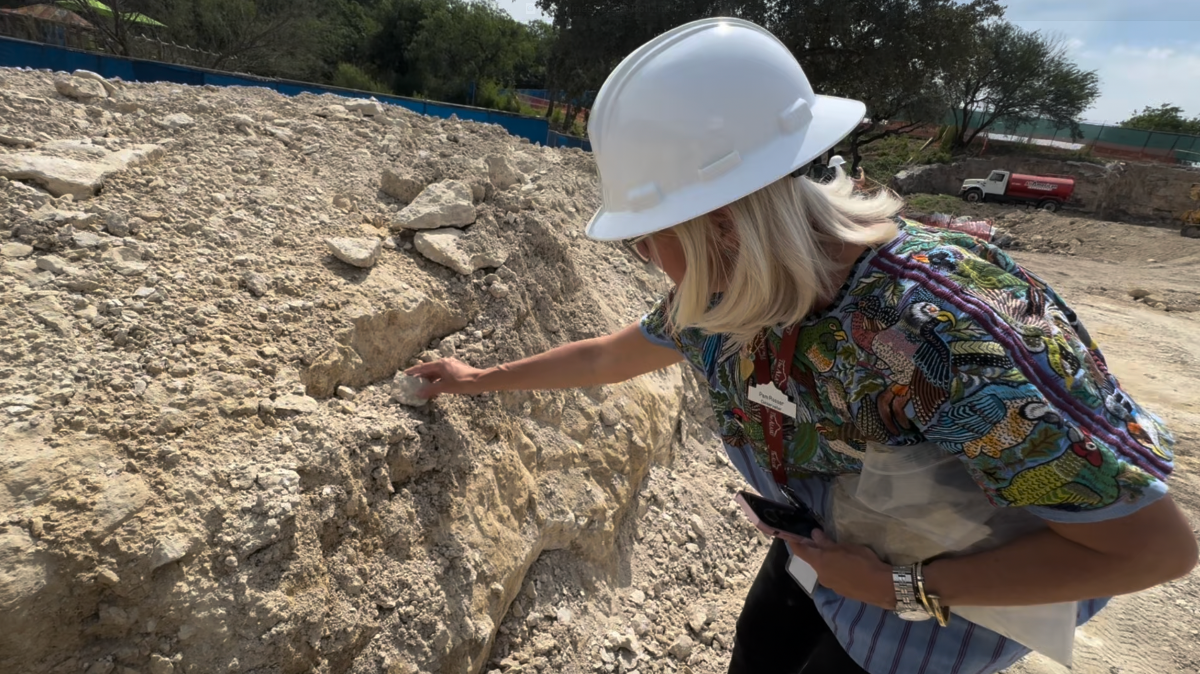 Women with white construction hat examining stone