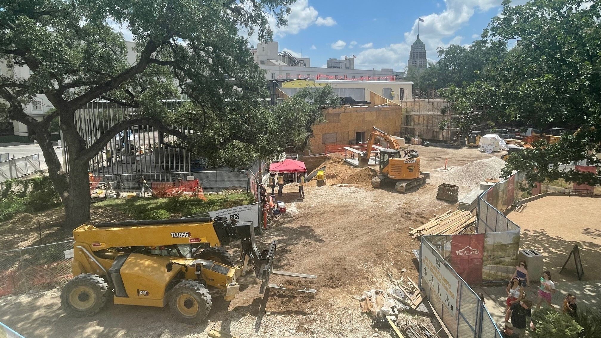 Construction trucks in a dirt area on Alamo grounds