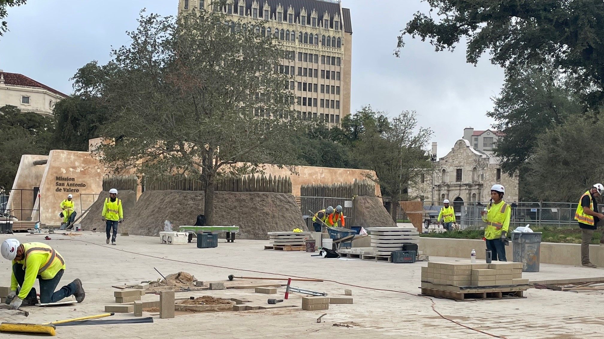 Construction workers laying pavers outside Mission Gate and Lunette
