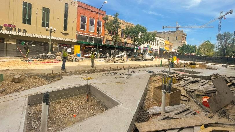Construction workers setting pavers on Alamo Promenade