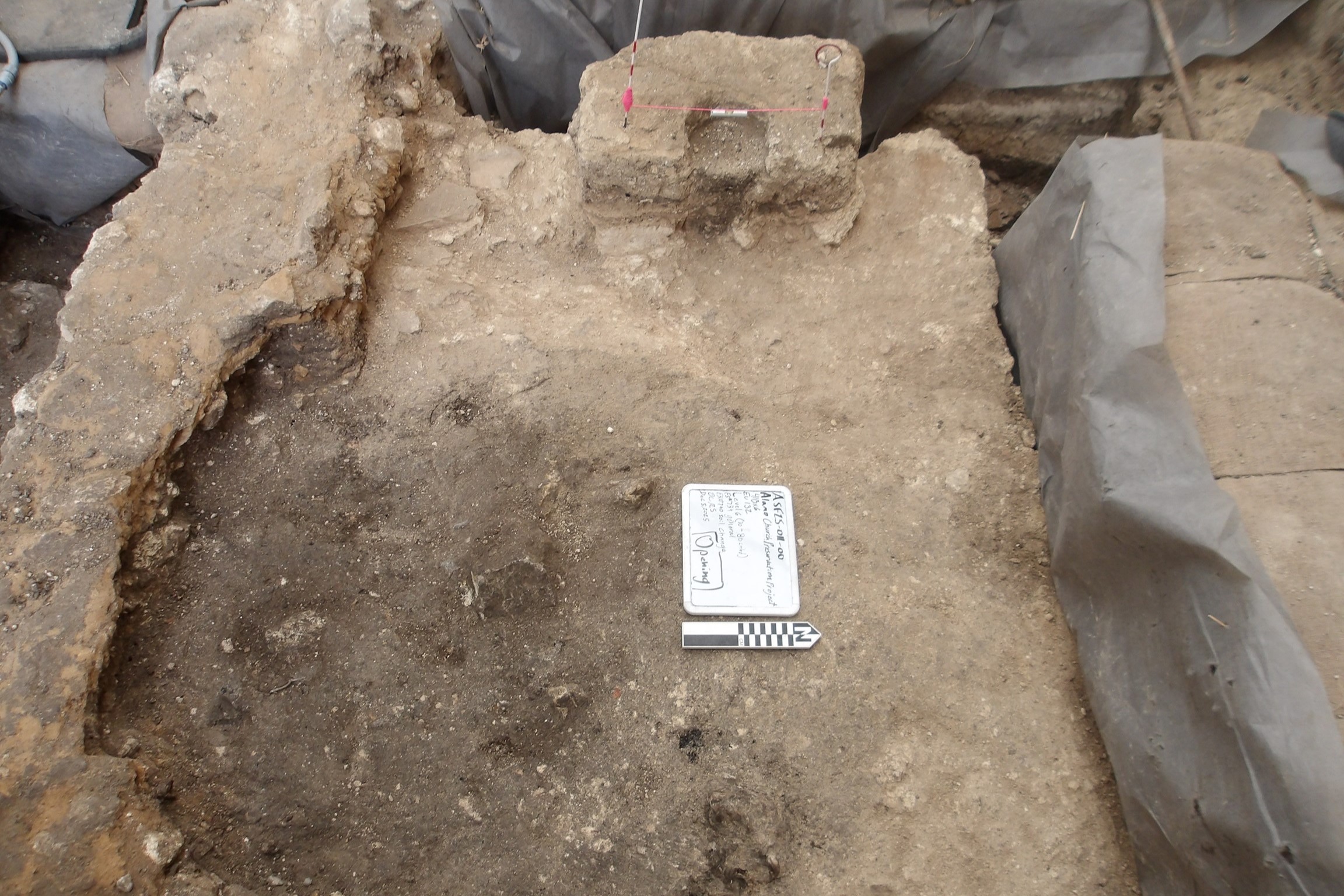 Excavation unit with posthole and darker soil changes