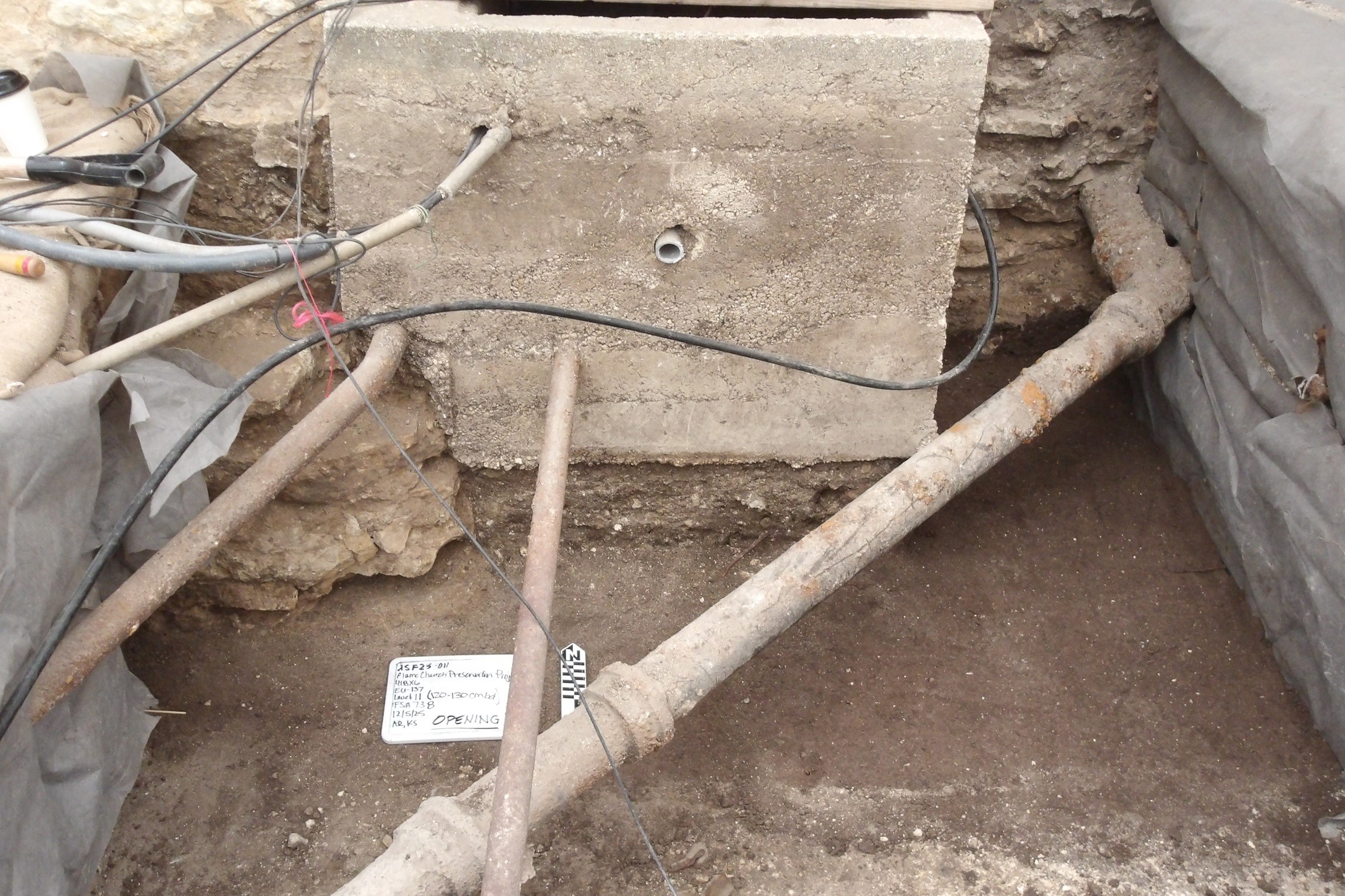Concrete utility vault with utility conduits inside an excavation unit
