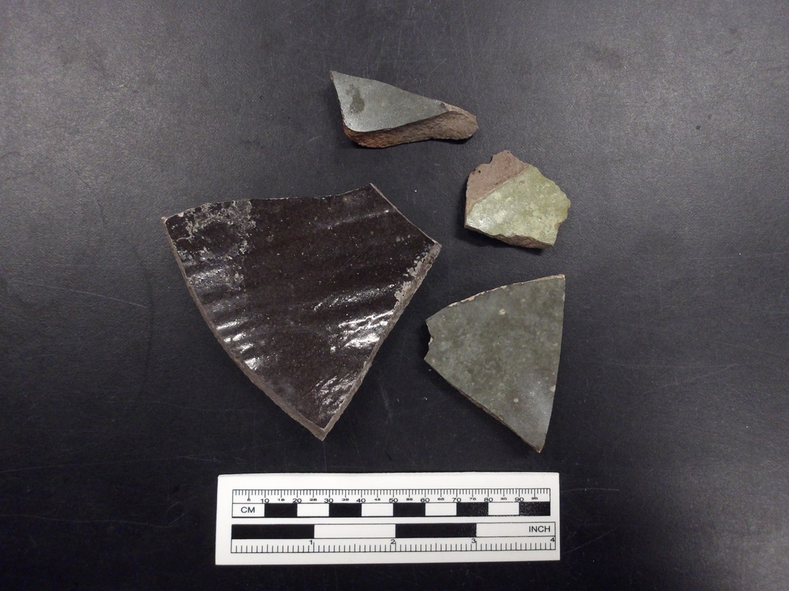 Stoneware ceramic sherds next to a ruler for size