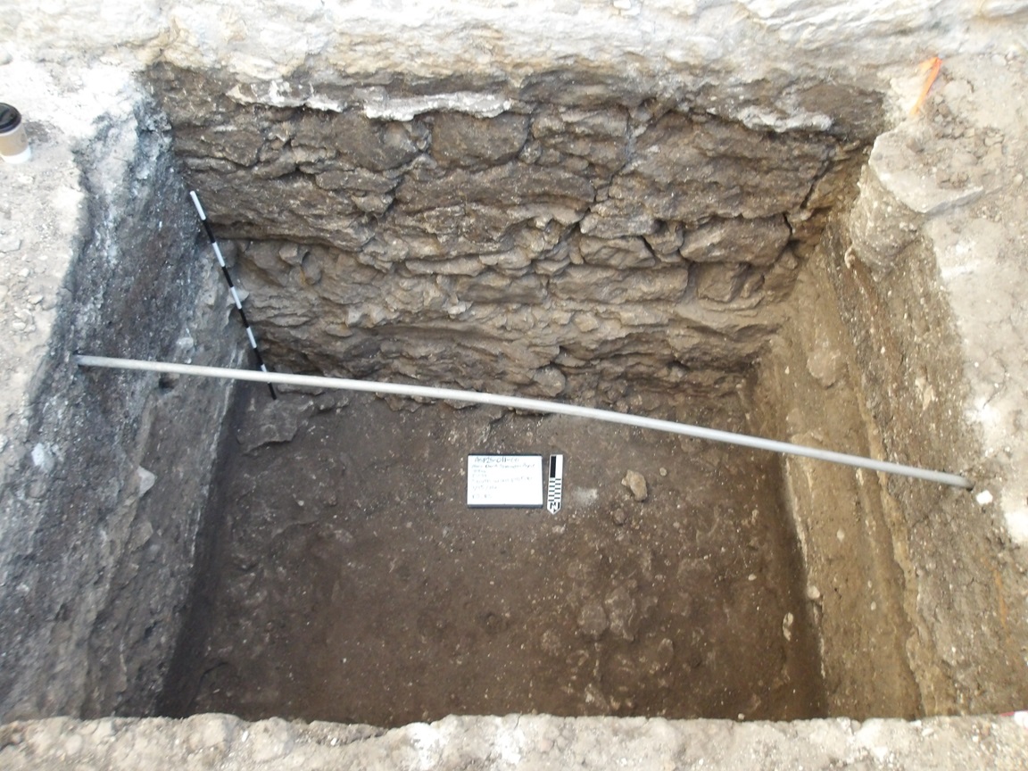 Inside an excavation unit 150 cm below surface with utility pipe across the top