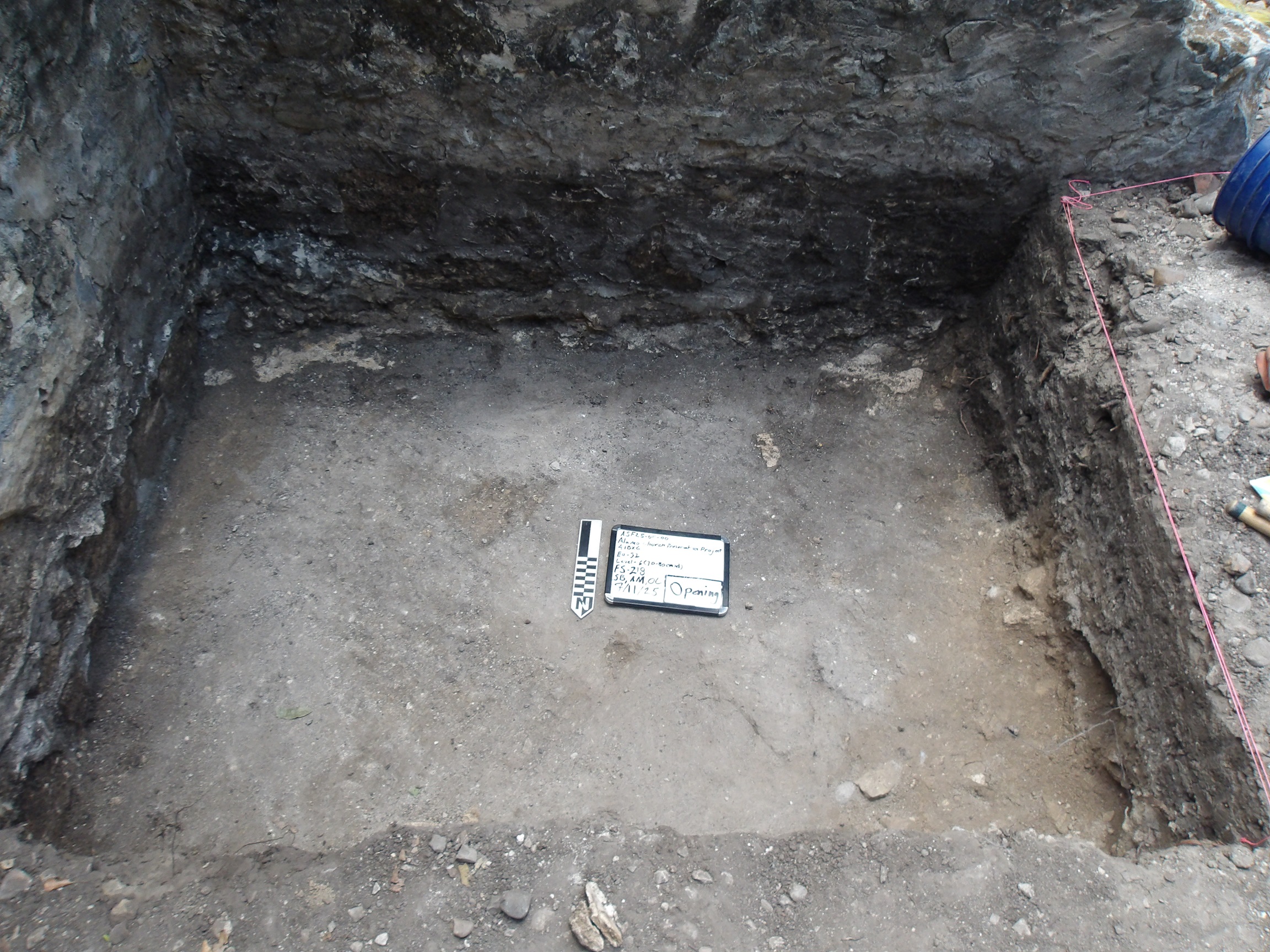 Inside of an excavation unit with a whiteboard and marker in the center
