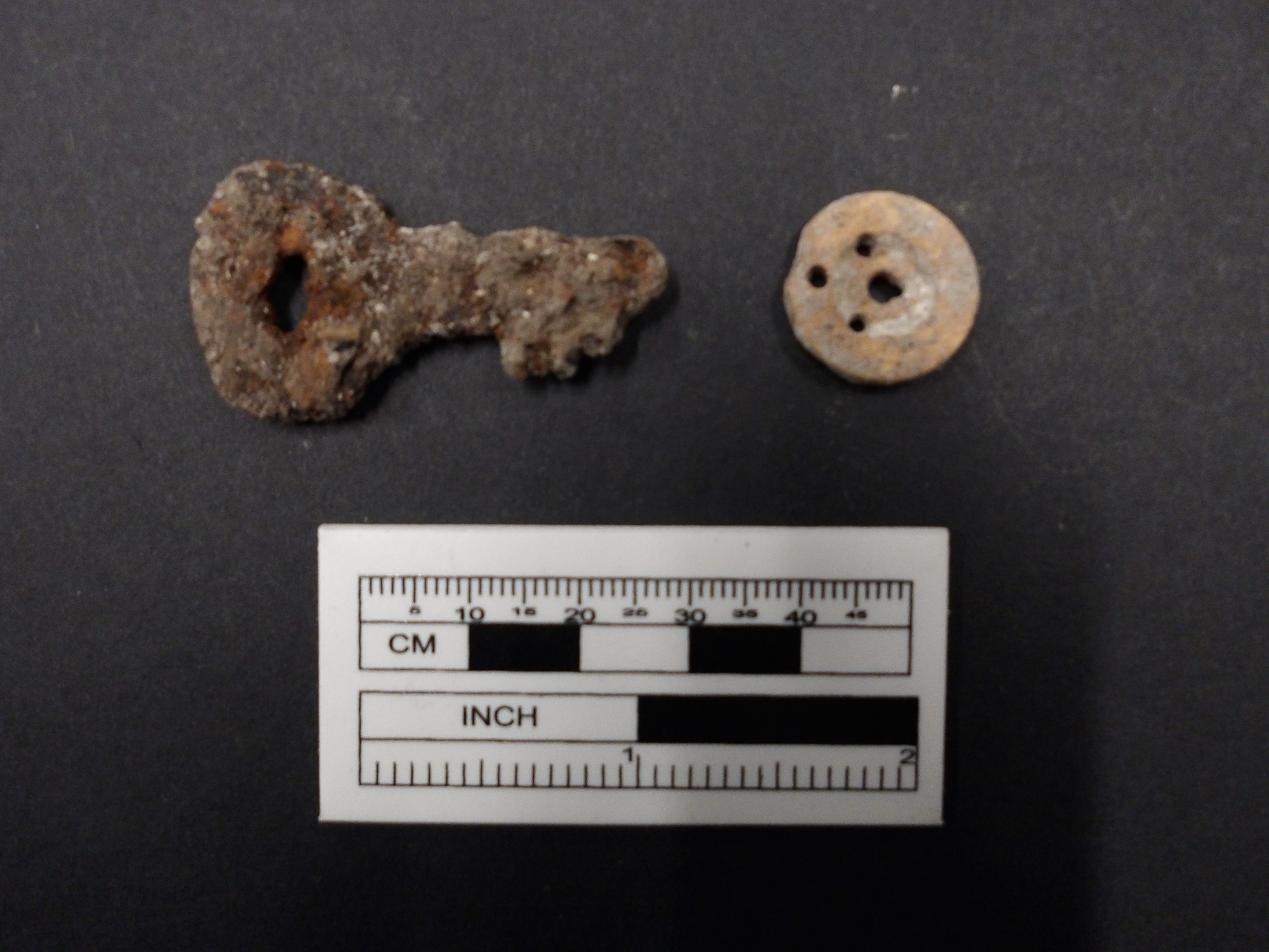 Key and a button recovered from excavation unit next to a ruler for size