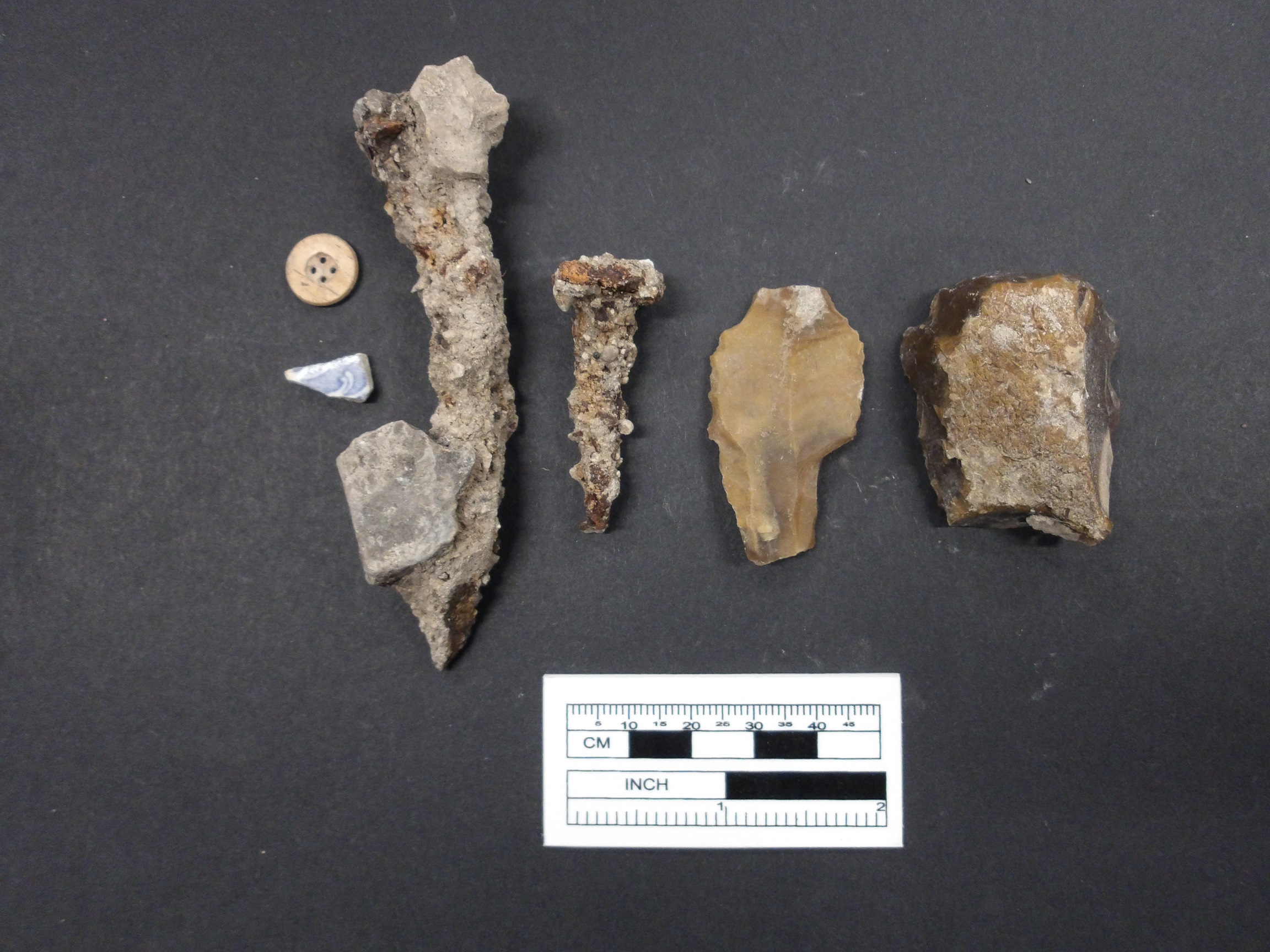 Hand wrought nails, 4-hole bone button, European ceramic sherds, and lithics from an excavation unit