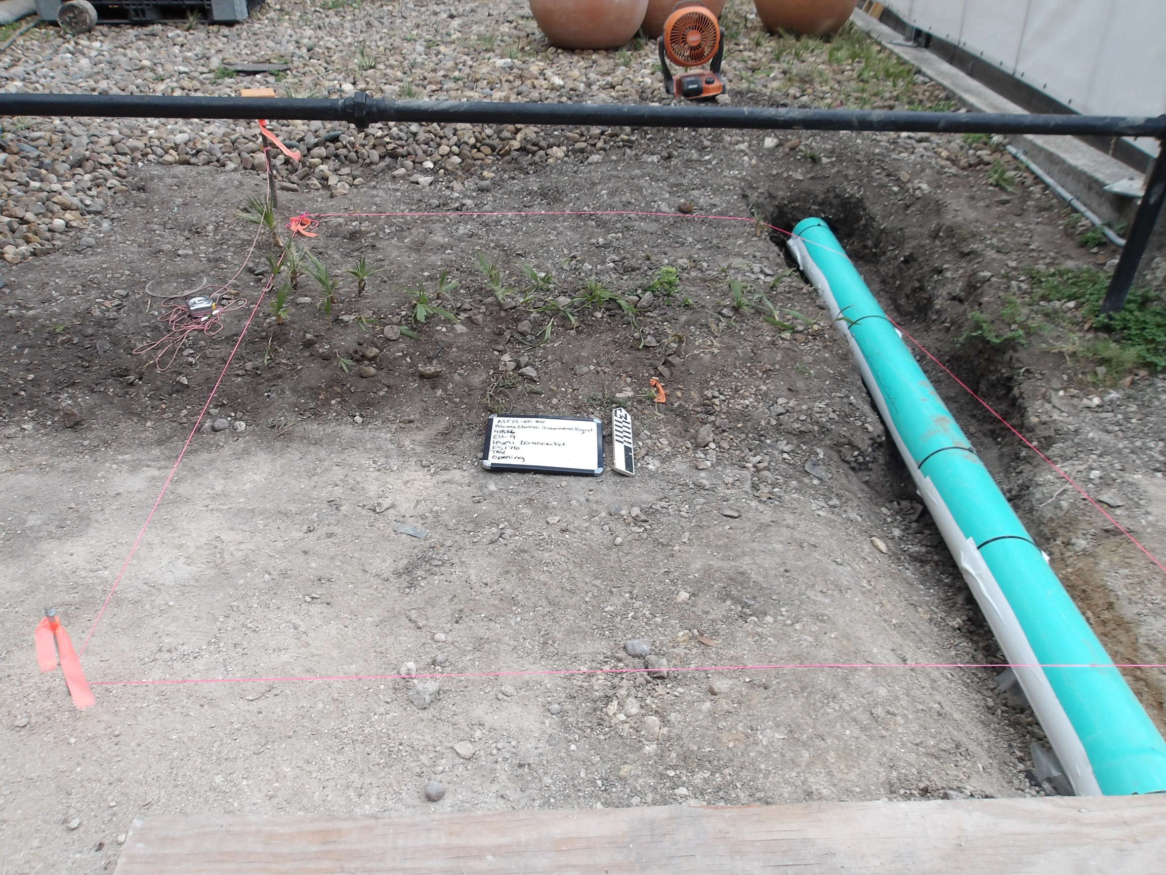 Inside of an excavation unit with green piping on the side