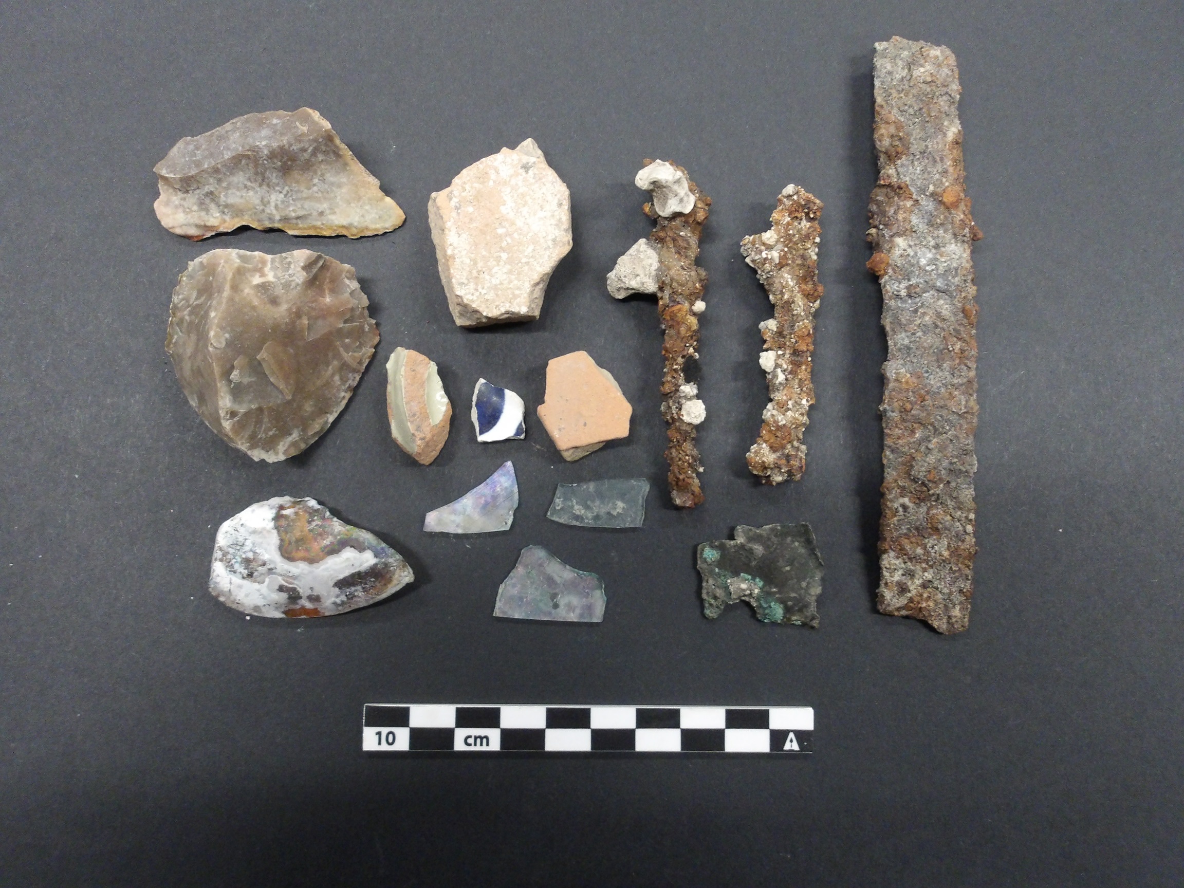 Rock fragment artifacts from an excavation unit next to a ruler for size
