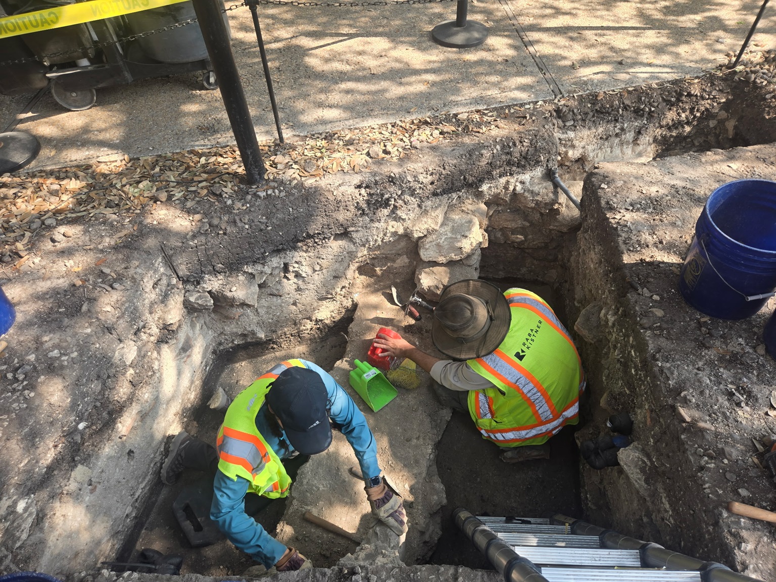 Two archaeologists working inside an excavation unit