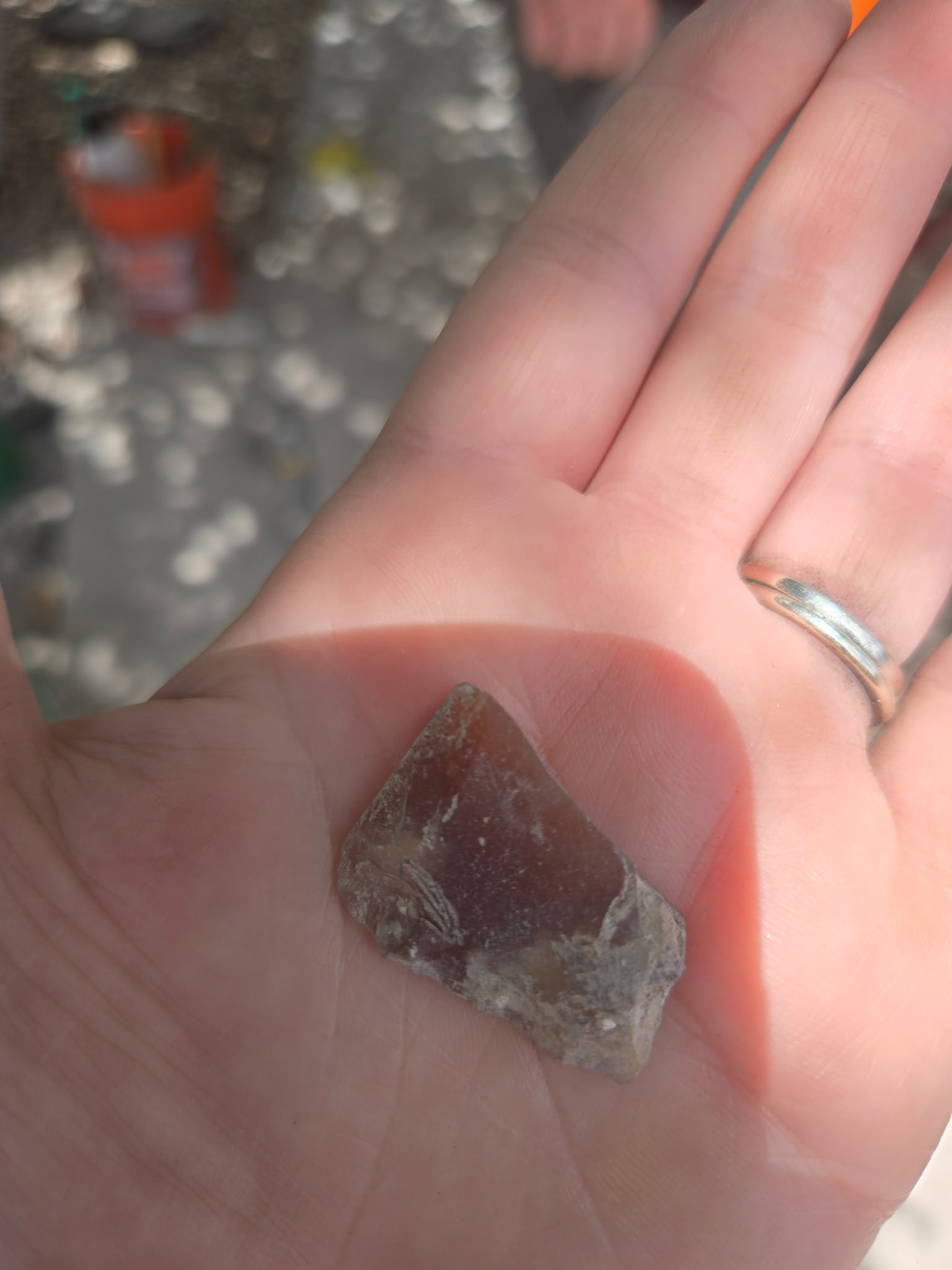Piece of gun flint from an excavation unit in the palm of a hand