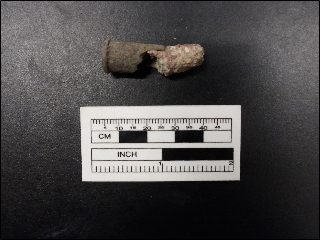 .38 caliber centerfire cartridge on a black background next to a ruler for size