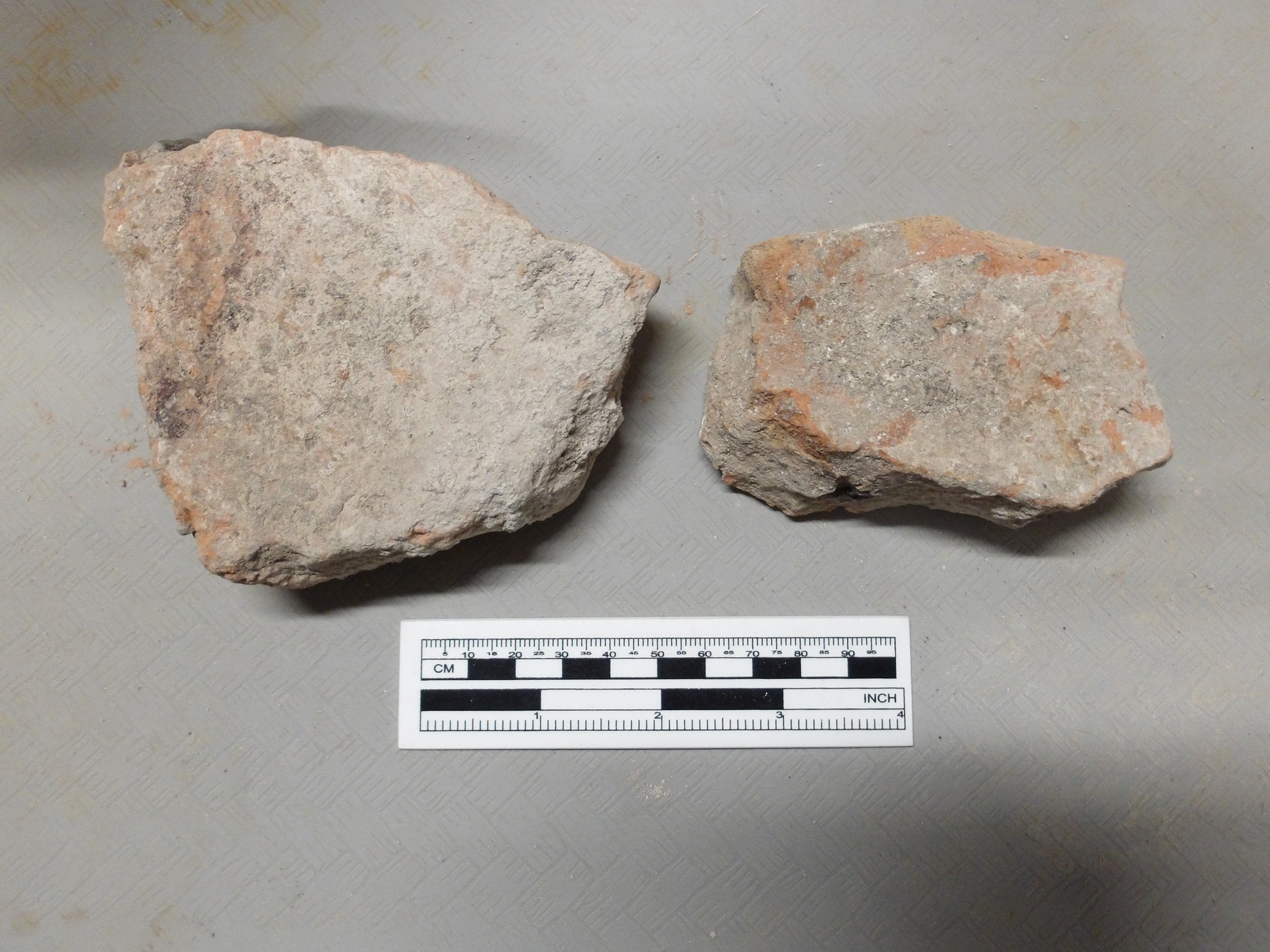 Two brick fragments next a ruler for size