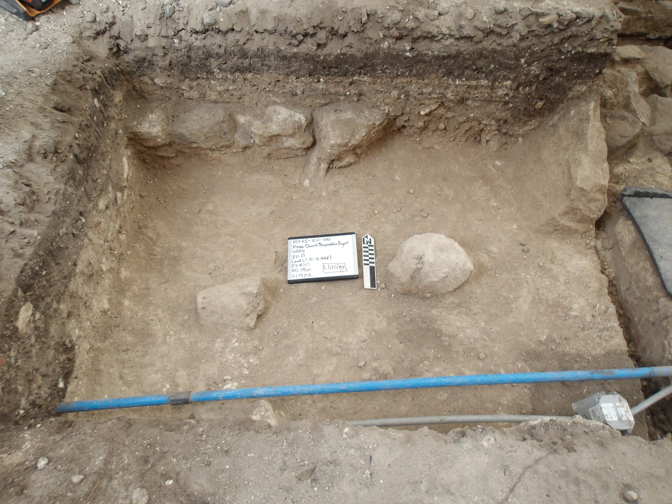 Brick fragments and utility conduits inside an excavation unit