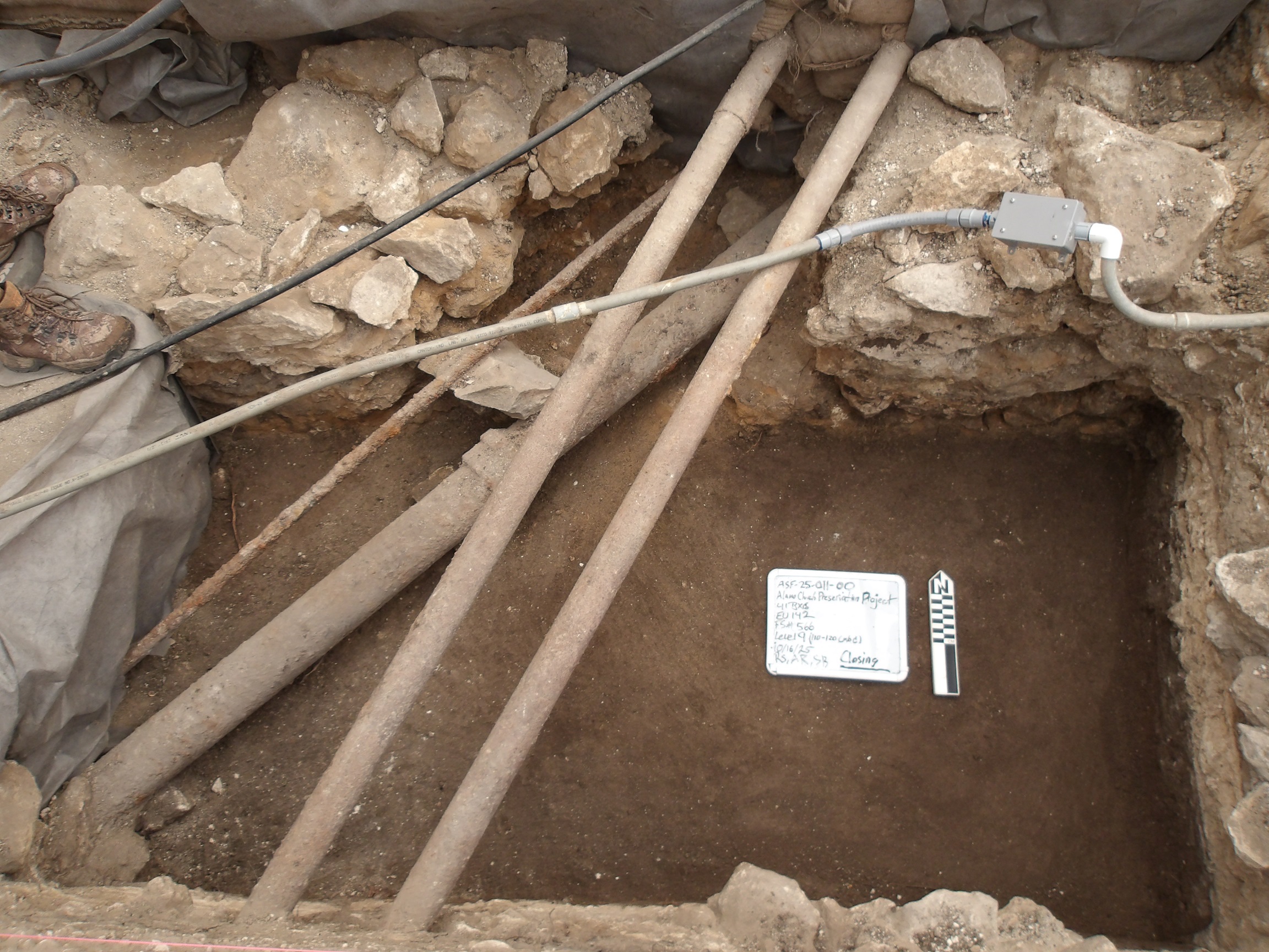 Utility conduits across the top of an excavation unit