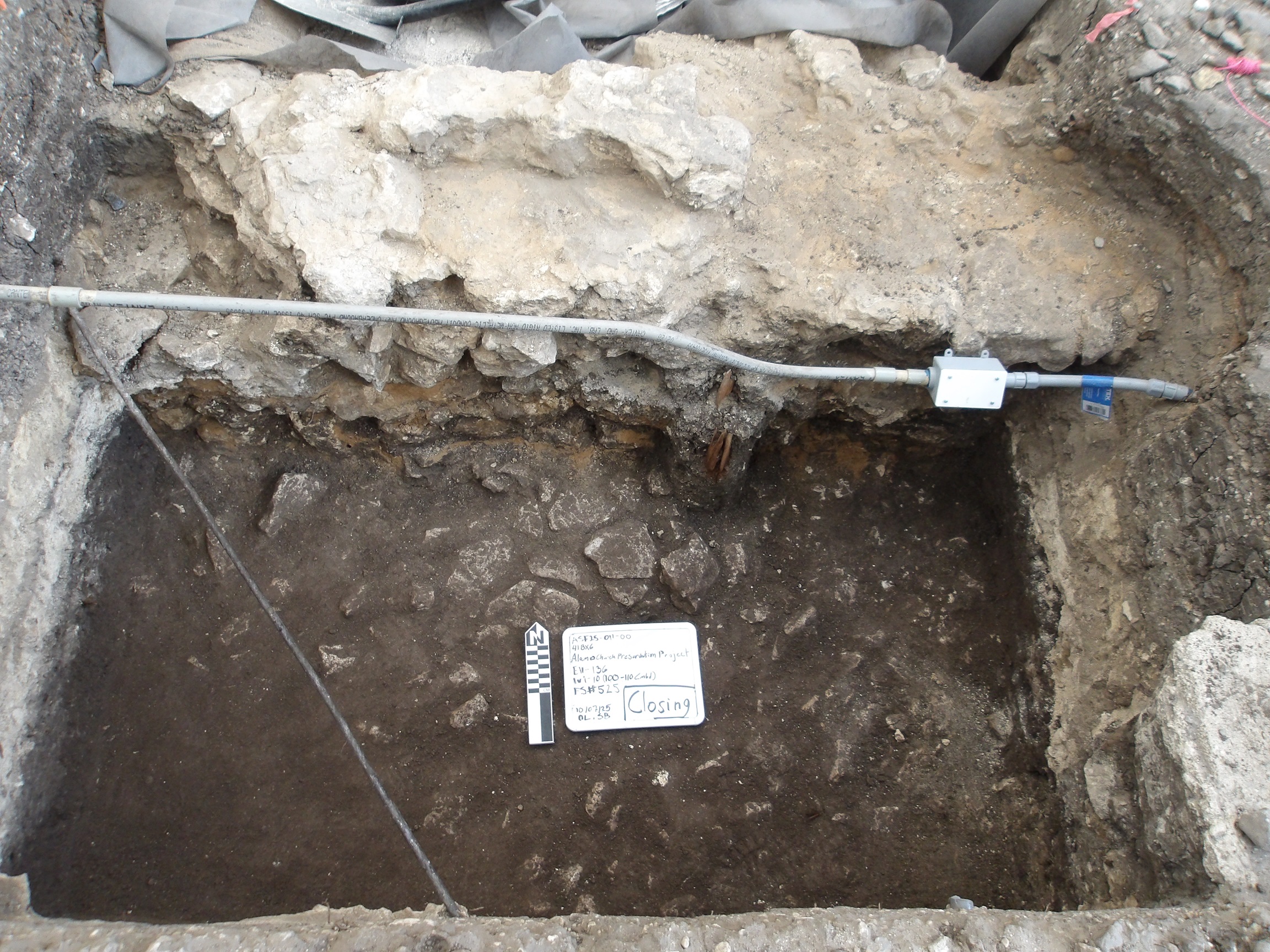 Limestone bottom covered with a dark mud in an excavation unit