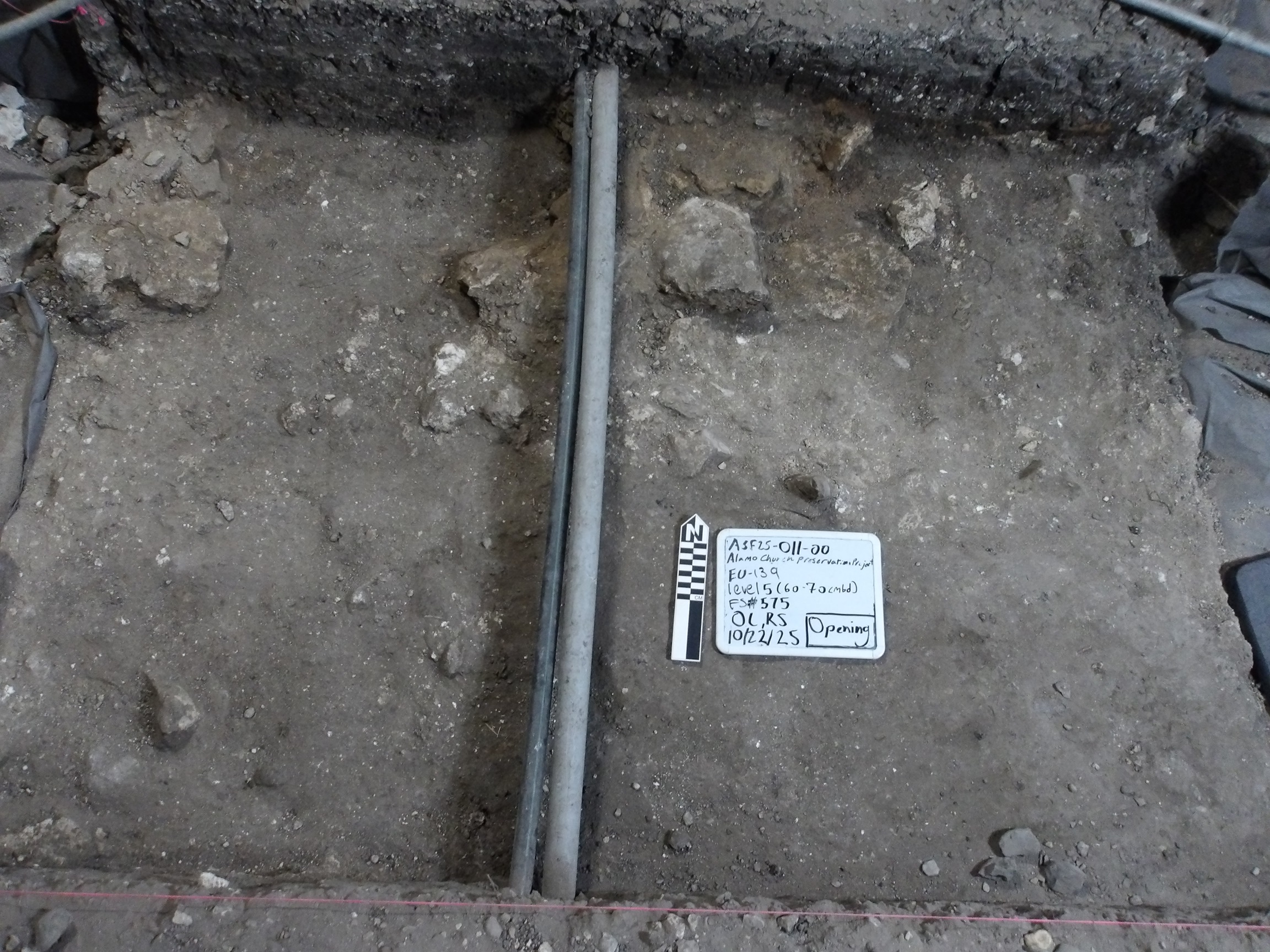 Pipe across a rocky surface at the bottom of an excavation unit